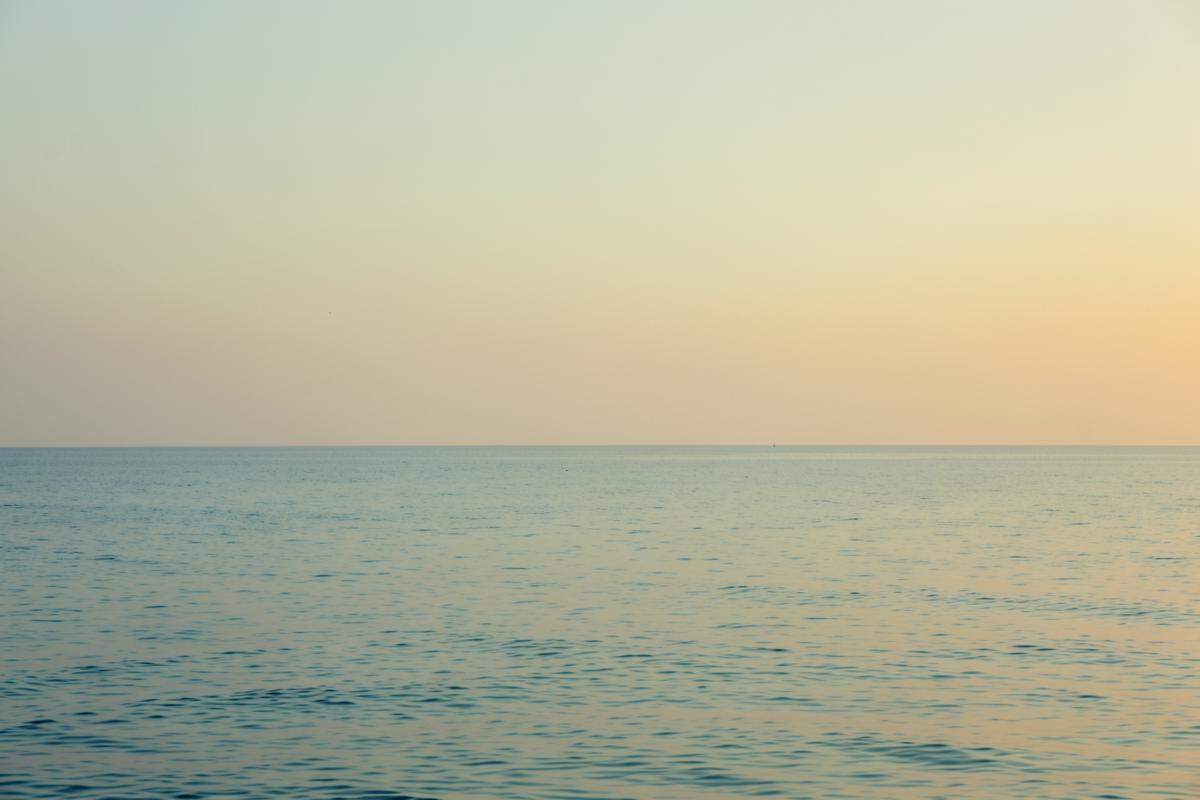 Mar en calma al amanecer con tonos dorados suaves